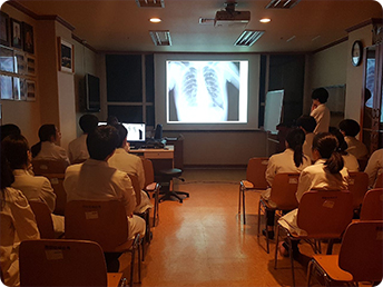 프로젝트 빔을 이용해 x-ray 사진을 보고 있는 컨퍼런스 장면
